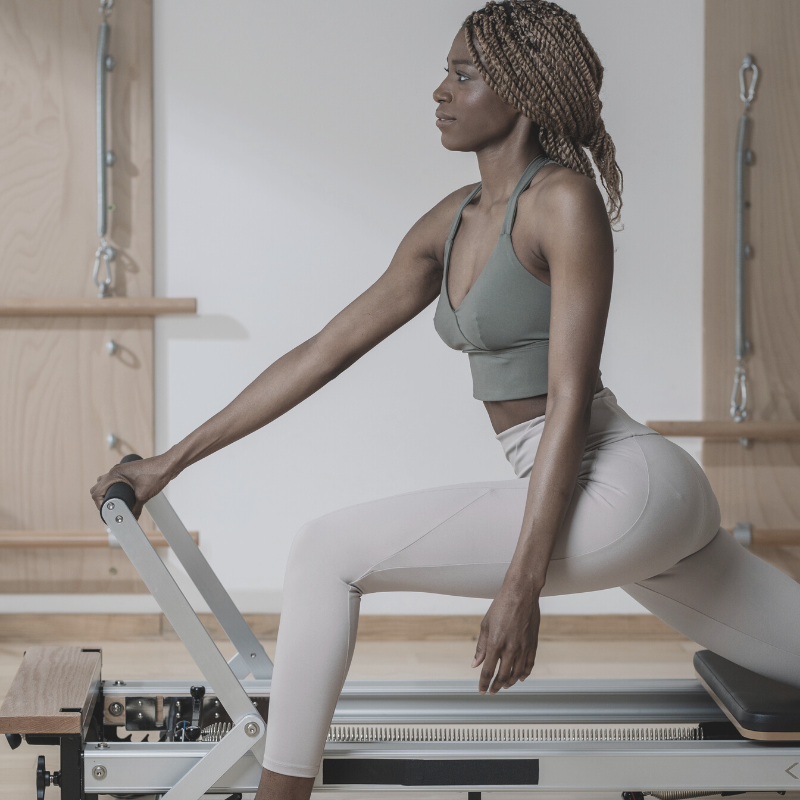 A pretty woman practicing Pilates with equipment