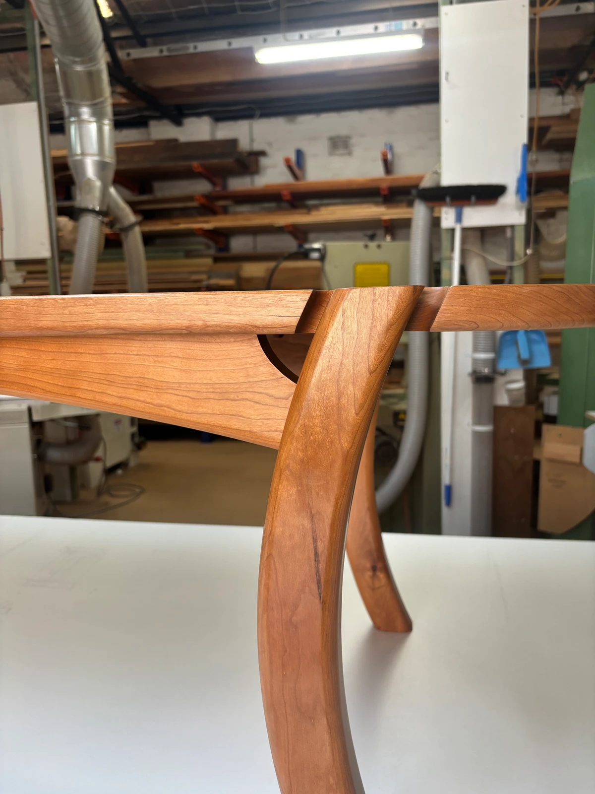 Close detail of a table leg meeting its timber rail.