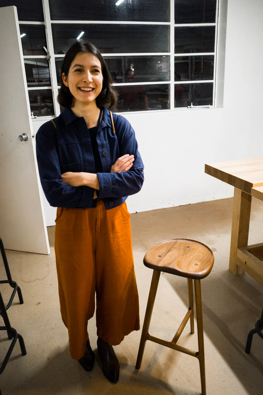 Chisel & Dowel student standing beside a finished furniture project in the Kingsgrove workshop.