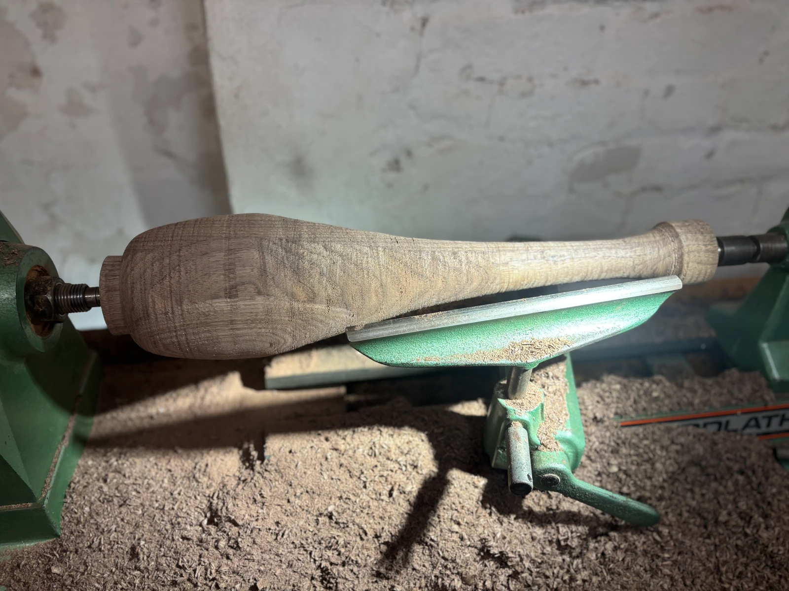 A close view of a shaped timber component on the lathe.