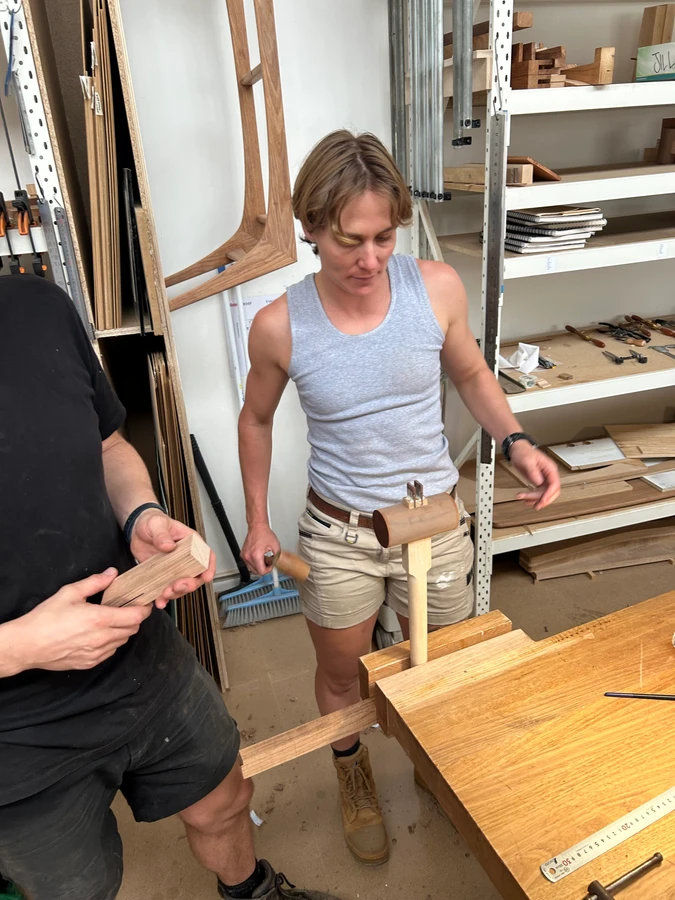 A student fitting a mallet handle into its wooden head.