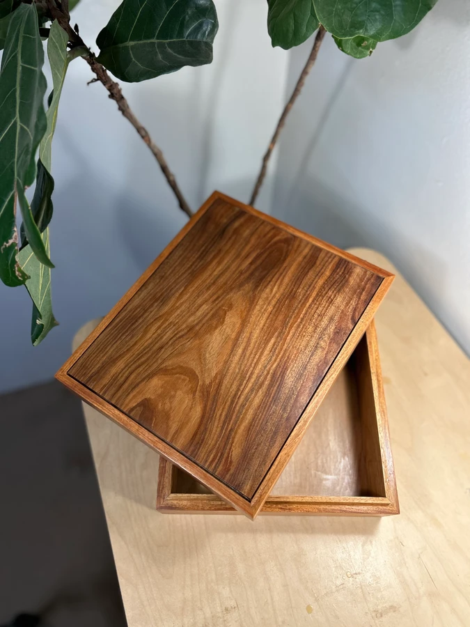 An open timber keepsake box with its lid resting across the top.