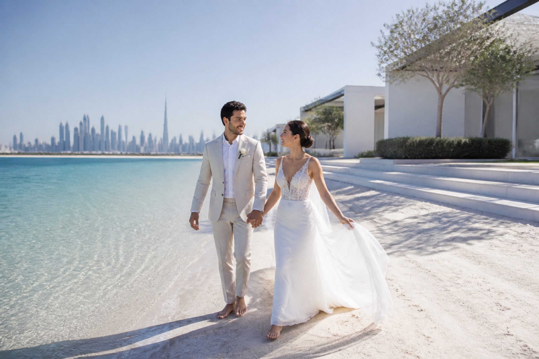 Newly married couple walking beside clear water at a private Dubai resort