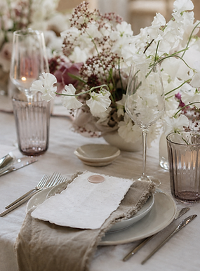 Elegant white and lilac floral wedding table setting.