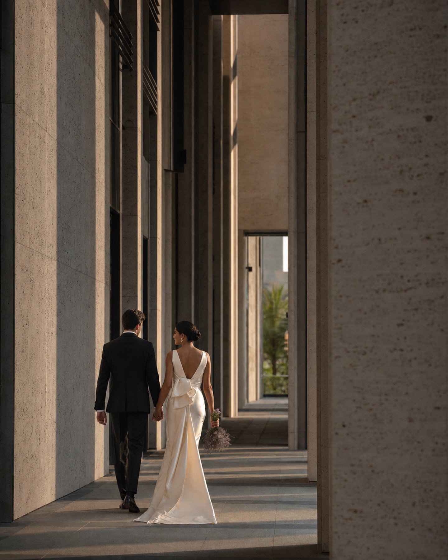 Newly married couple walking through contemporary Dubai architecture