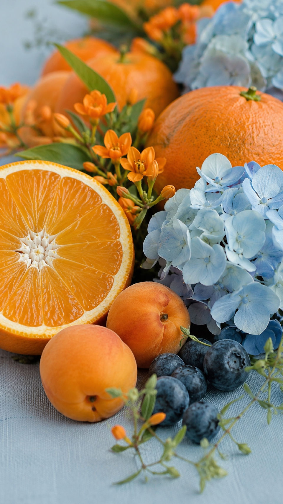 Citrus, peaches, blueberries and blue hydrangea styled for a graduation dinner