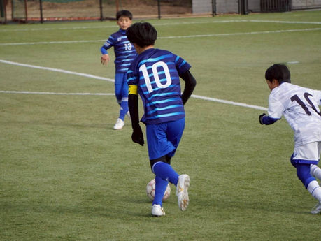 サッカーボールを蹴る少年