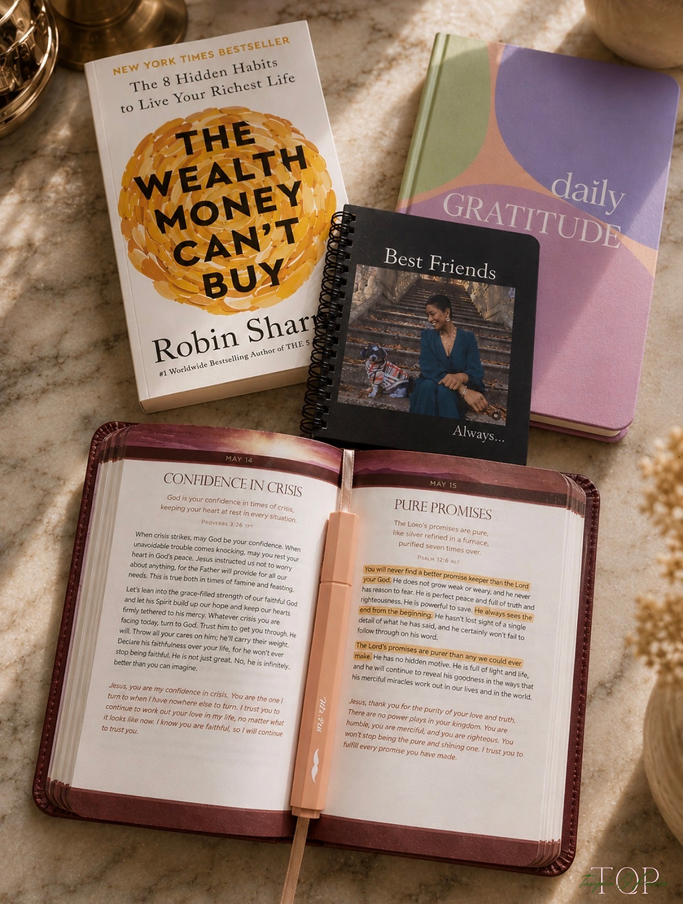 Author and healthcare marketing executive Tangela Parker studies her devotional and gratitude journal during a quiet morning routine on a marble table surrounded by books, highlighted passages, and warm natural light.