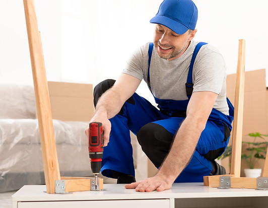 Professional Craftsman Carpenter Assembling Table Using Electric Drill Working Indoor Furn