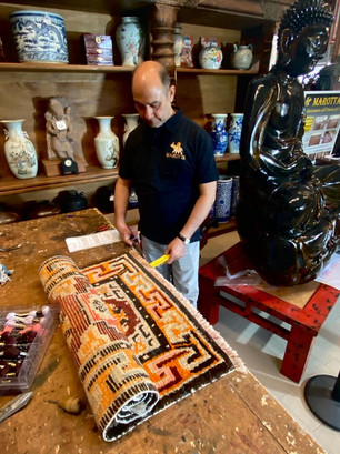 artigiano spazzola un tappeto persiano che viene restaurato