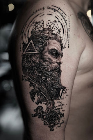 Realistisk överarmstatuering av grekisk gud med skägg, detaljerade ornament och geometriska symboler, utförd av tatuerare stockholm.