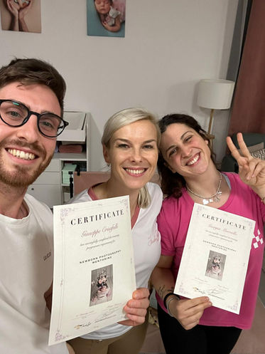 Masha con due fotografi sorridenti, che mostrano certificati di mentoring newborn