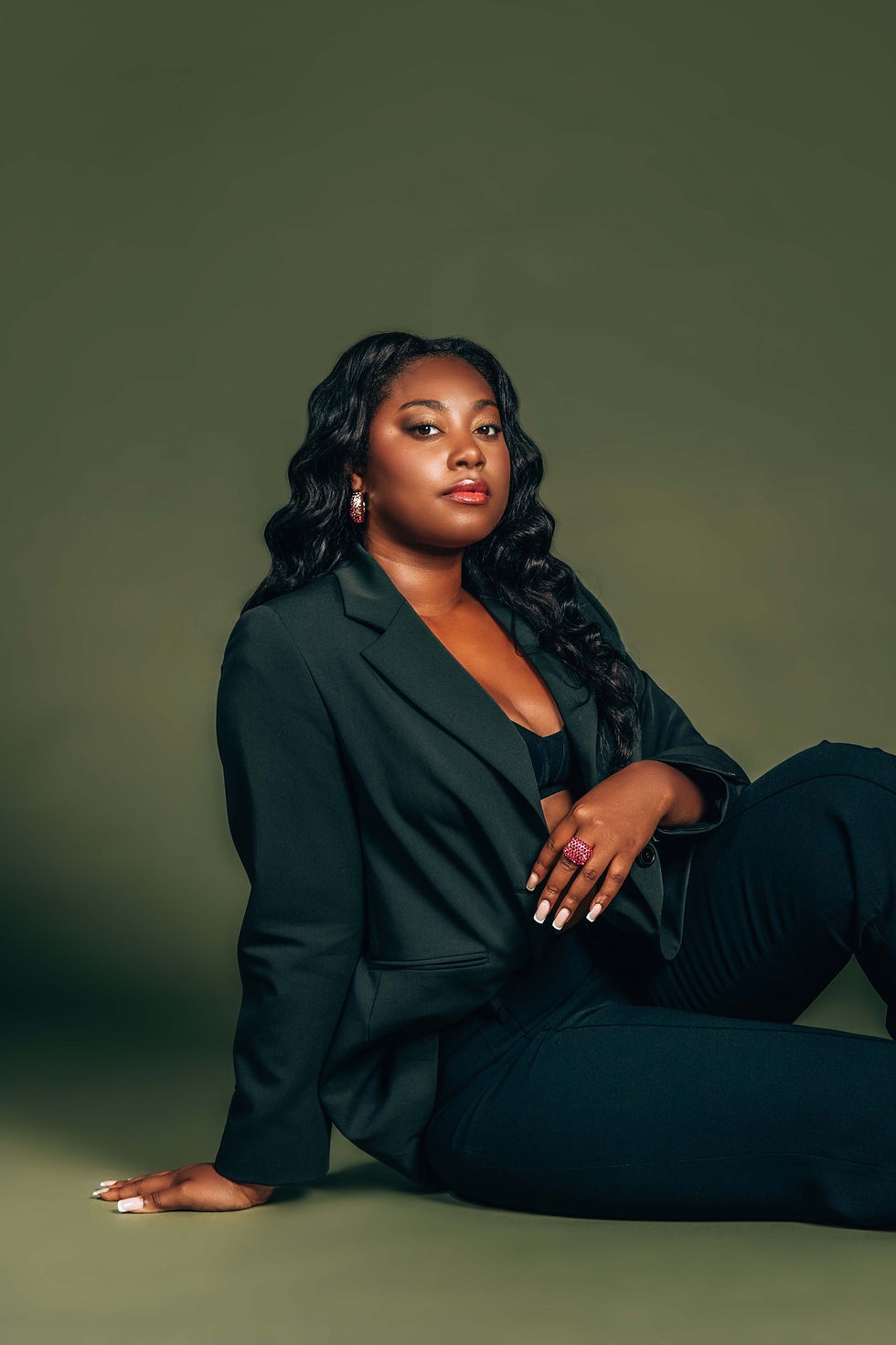 relaxed-black-model-editorial-portrait-sitting-blazer-green-backdrop.jpg