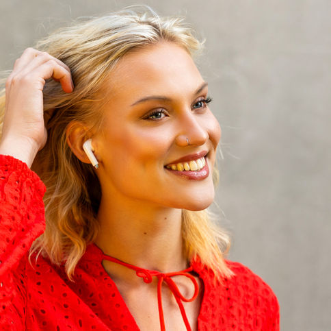 Campaign photoshoot of Thunderz earphones. Blonde female model wearing white earphones in her ear