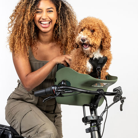 Model photoshoot for kvisp dog bike seats. Model riding bike and dog sits in the dog seat.