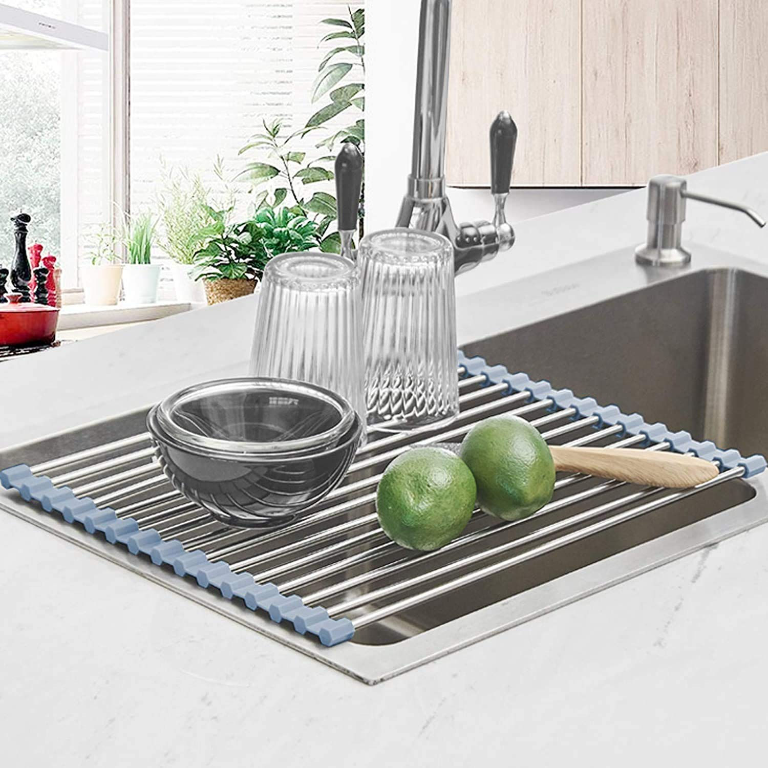 Roll-up stainless steel dish drying rack placed over a kitchen sink