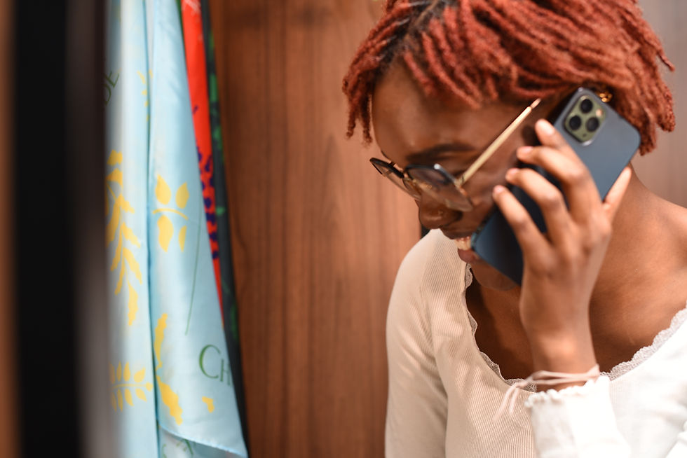 A black woman with red locs talks to a customer on the phone