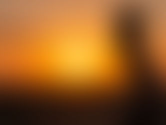 Lady walking with a bucket on her head in the sunset