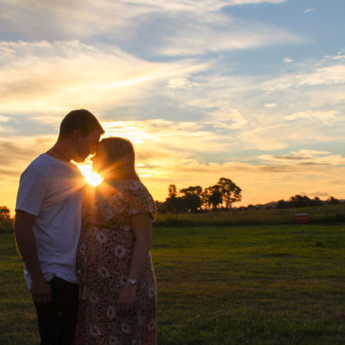 Sun peeking through a couple's photo on a farm. 
