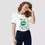 Miniature : T-shirt kiss me Saint-Patrick blanc. Un haut unisexe doux en coton bio, porté par mannequin femme. Exclusif pour le 17 mars.