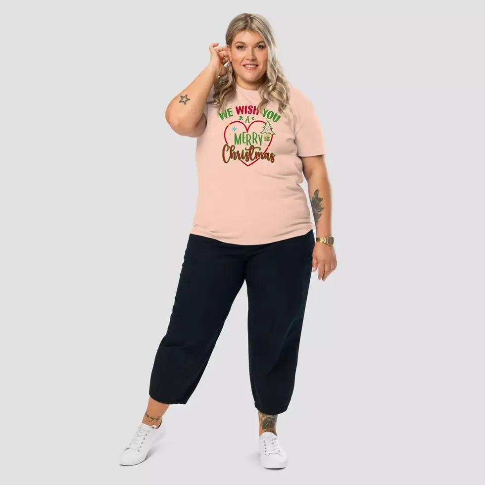 Miniature : T-shirt coeur Noël unisexe. Un haut couleur peche porté par une femme. Design sur un coton bio ultra doux et respirant.