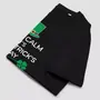 Miniature : T-shirt reste calme St-Patrick unisexe et slogan en anglais. Fabriqué en coton bio. Haut noir plié pour montrer les détails.