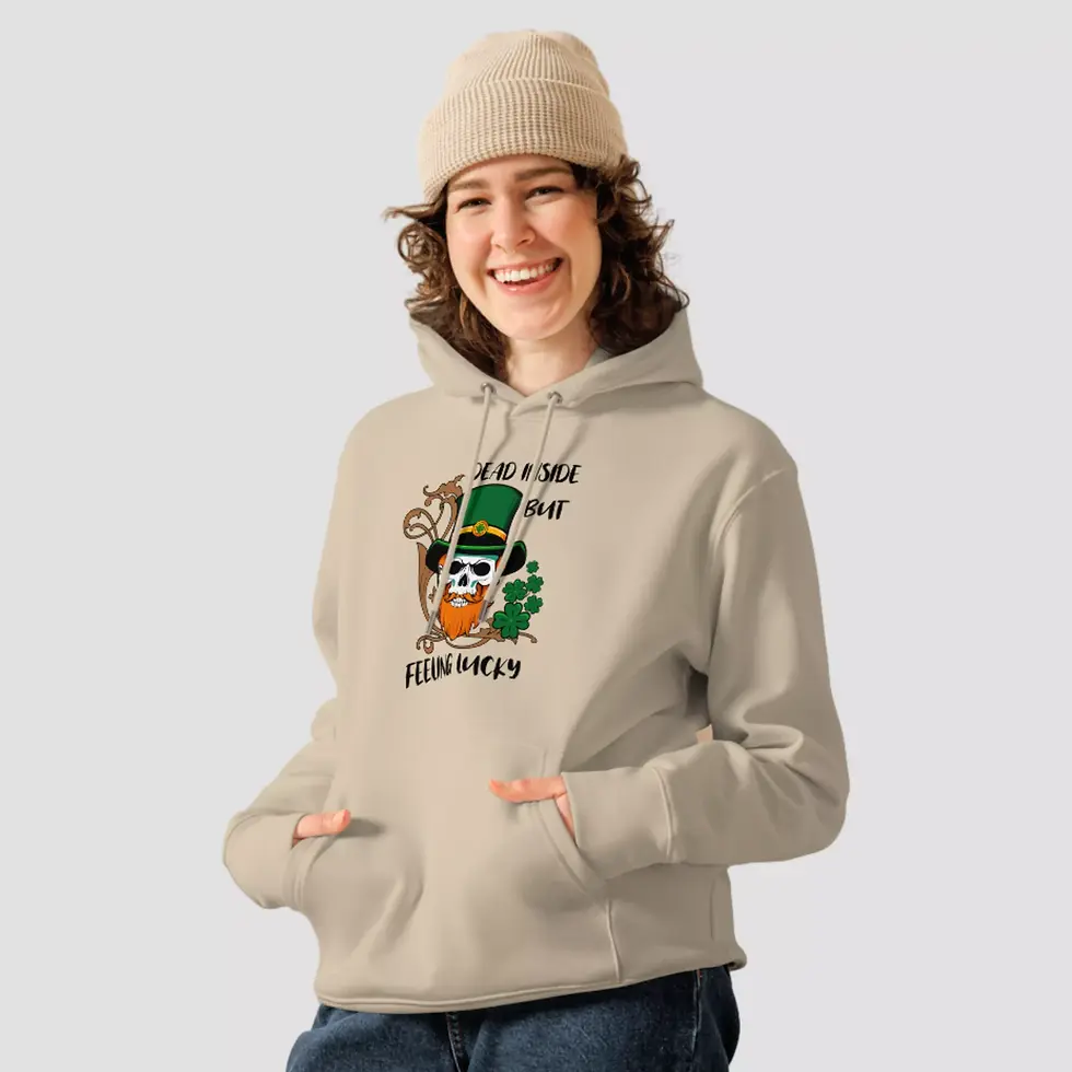 Miniature : Sweat à capuche crâne Saint Patrick sable. Haut unisexe mis en valeur par une femme. Design imprimé sur un coton bio et doux.