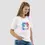 Miniature : T-shirt chat kawaii blanc. Ce haut est porté par un mannequin femme. Le vêtement est en coton bio avec une coupe unisexe.