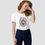 Miniature : Une femme avec un t-shirt blanc avec un imprimé chat sorcière magie pour Halloween.