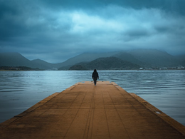 Photo of a Person at a Distance Reflecting on a Mountain