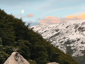 A mountain with snow and a mountain that is thawed.