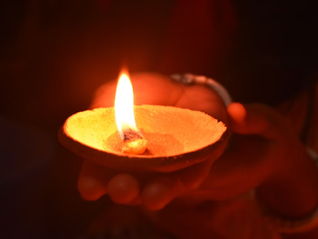 A traditional oil lamp held in hands at night