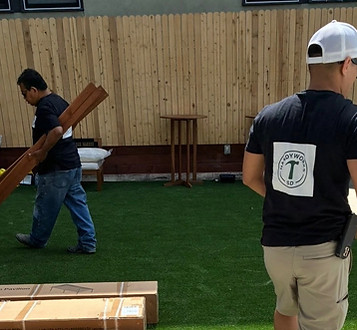 Workers building a fence on a residential lawn