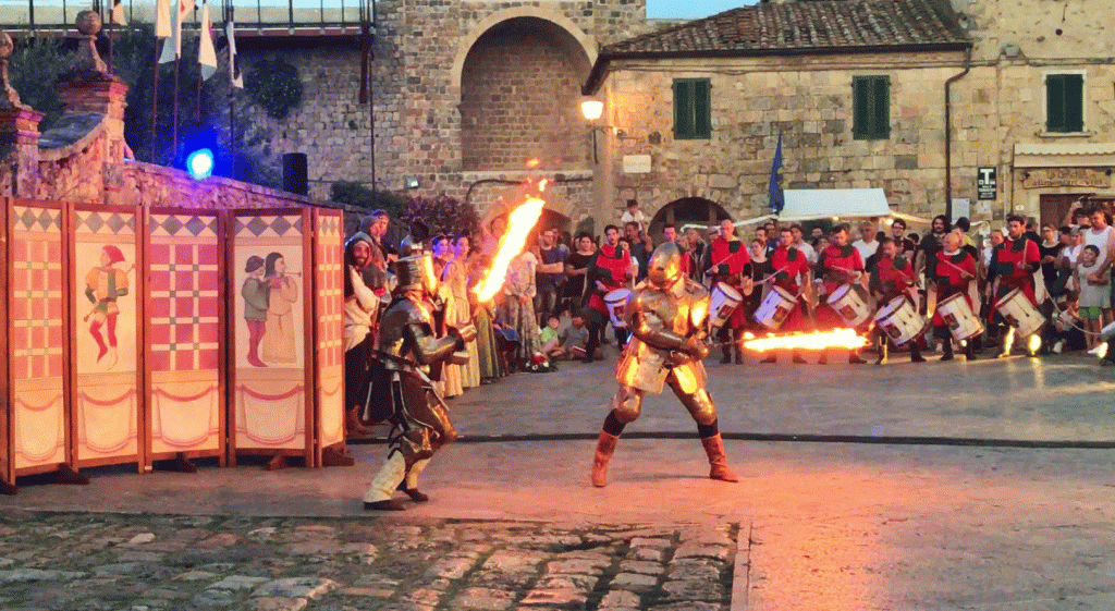 two knights in armor fighting with flaming swords at a medieval festival in Monteriggioni, Italy