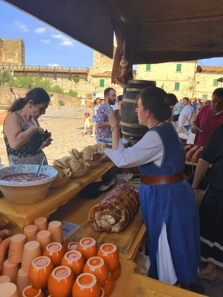 barmaid selling pork sandwiches at a kiosk at a medieval festival