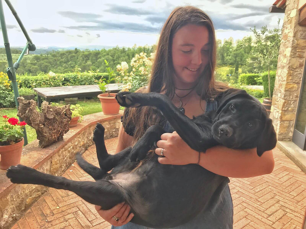 girl holding a black puppy in tuscany