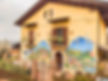 bright yellow house in Azzinano Italy with a beautiful mural