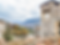 ancient limestone clock tower in autumn with mountains in the background and the off the beaten path town of Fontecchio in Abruzzo, Italy