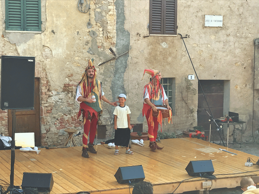 medieval jesters and young boy playing jokes at Italian medieval festival