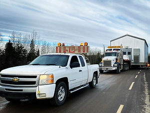 pilot car in front of oversized load on road