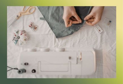 hands pinning fabric to be sewn on machine
