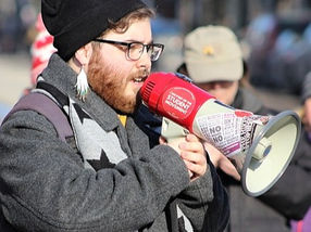 Photo of Engage Barrie Organization's contributing member, Brandon Rhéal Amyot, speaking into a megaphone