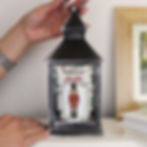 Person holding illuminated Christmas lantern with Nutcracker design and personalized message