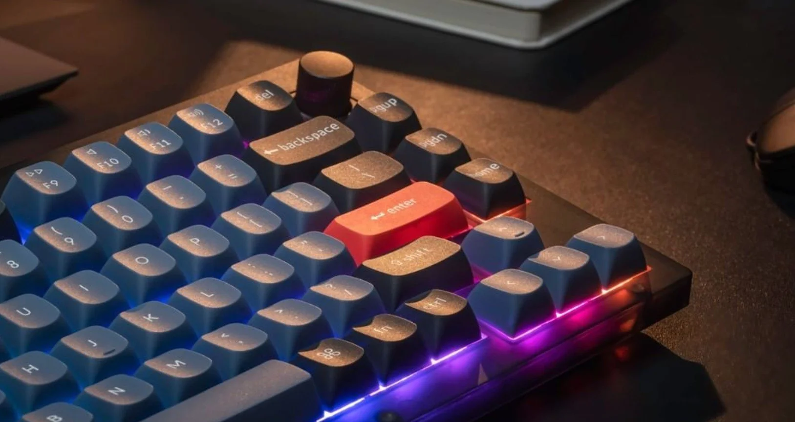A close-up image of a Keychron K Series mechanical keyboard with RGB backlighting and a wireless connection.