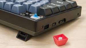 A close-up image of a Keychron K Series mechanical keyboard with RGB backlighting and a wireless connection.