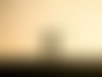 A silhouette of a person with their arms outstretched against a golden sky.