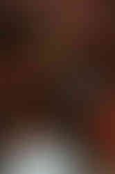 Editorial fashion portrait with model seated in red leather booth