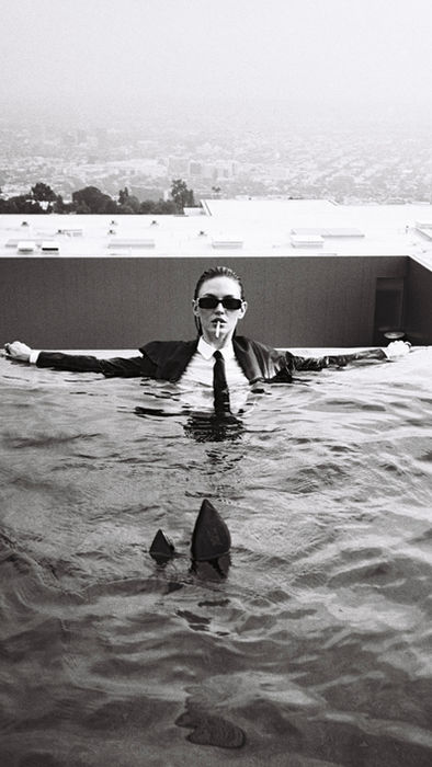 Monochrome editorial portrait of model in a swimming pool