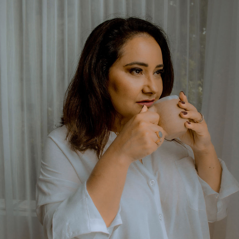 Mulher em momento reflexivo segurando uma xícara de chá.