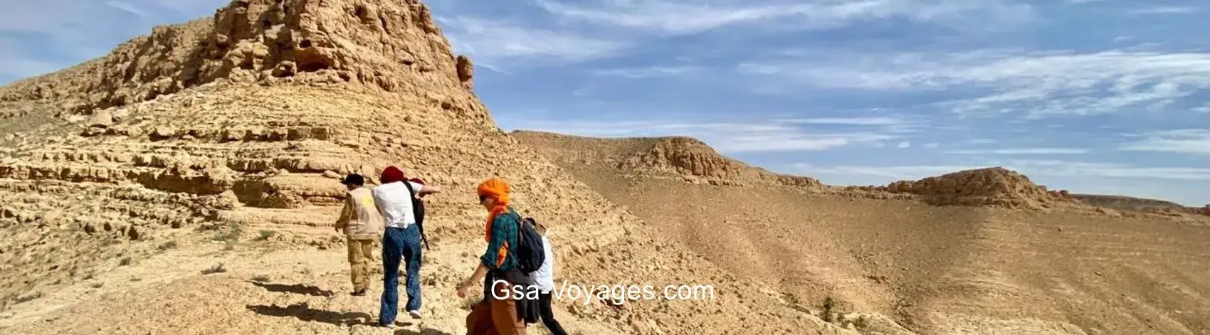 Randonnée dans le Djebel Dahar – Trois marcheurs sur les crêtes rocheuses depuis Tozeur